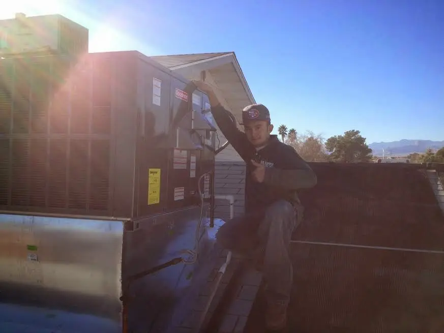 HVAC technician performing HVAC Inspection on a rooftop unit in Libertyville